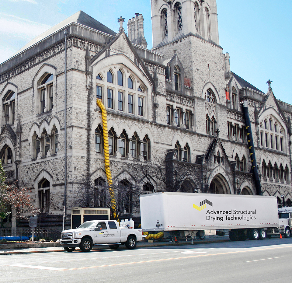 ASDT truck in front of a building at work